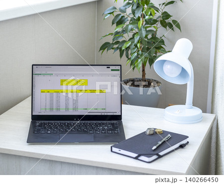 Laptop Showing Monthly EMI Calculations Next to Stacked Coins Laptop Showing Monthly EMI Calculations Next to Stacked Coins 140266450