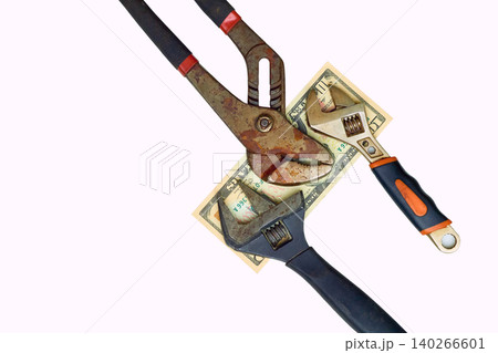 Paying.Ten dollars bill between old adjustable wrenches Paying.Ten dollars bill between old adjustable wrenches 140266601