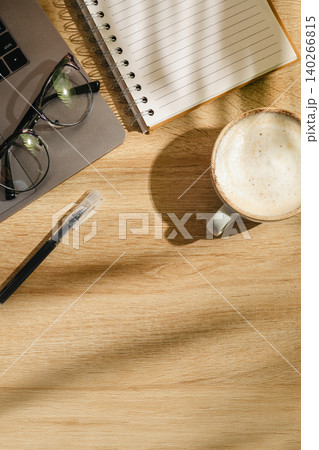 Home office workspace with notebook, coffee and eyeglasses on wooden desk, top view with copy space Home office workspace with notebook, coffee and eyeglasses on wooden desk, top view with copy space 140266815