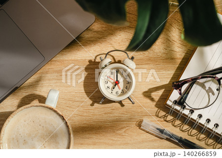 Time management concept with alarm clock, laptop and coffee on home office desk, top view workspace Time management concept with alarm clock, laptop and coffee on home office desk, top view workspace 140266859