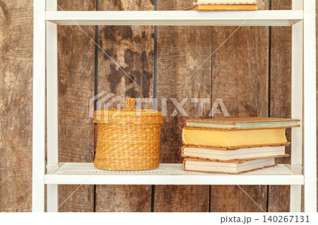 Close up of white bookshelf against grunge wooden wall 140267131