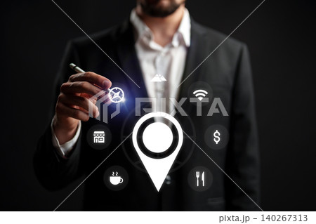 Man holds pen near map icon while planning a taxi route in a city setting at night Man holds pen near map icon while planning a taxi route in a city setting at night 140267313