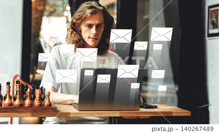 Man working on laptop while emails appear in a cafe during the day Man working on laptop while emails appear in a cafe during the day 140267489