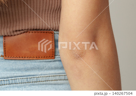 Close view of a persons elbow and part of their outfit in a simple indoor setting Close view of a persons elbow and part of their outfit in a simple indoor setting 140267504