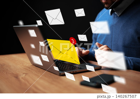 Message notifications appear on computer while a man works at a desk during morning hours Message notifications appear on computer while a man works at a desk during morning hours 140267507