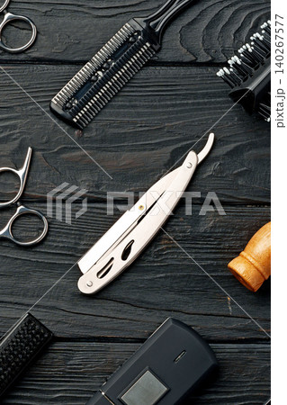 Tools arranged on a dark wooden surface for hair cutting and styling tasks in a barbershop Tools arranged on a dark wooden surface for hair cutting and styling tasks in a barbershop 140267577