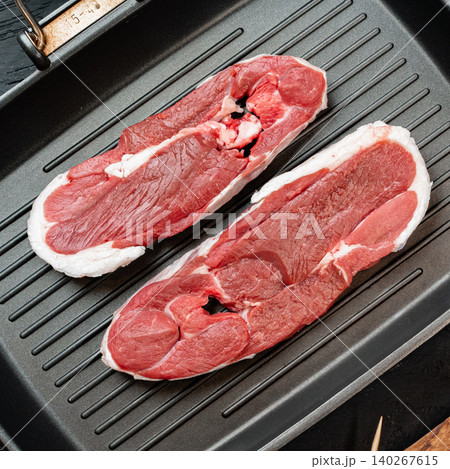Fresh cuts of meat placed on a grill pan ready for cooking and seasoning Fresh cuts of meat placed on a grill pan ready for cooking and seasoning 140267615