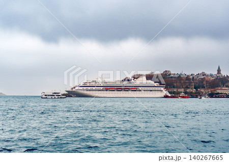 Cruise ship docked near the shoreline in the harbor during cloudy weather 140267665