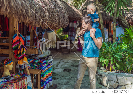 Dad walks with his infant on his shoulders among lush plants, showing fatherhood, travel with baby, jungle adventure and family vacation concept Dad walks with his infant on his shoulders among lush plants, showing fatherhood, travel with baby, jungle adventure and family vacation concept 140267705