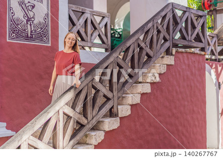 Female tourist walks and twirls through colonial arches, tiled floors and stone details, showing Mexico travel, culture and elegant vacation style concept Female tourist walks and twirls through colonial arches, tiled floors and stone details, showing Mexico travel, culture and elegant vacation style concept 140267767