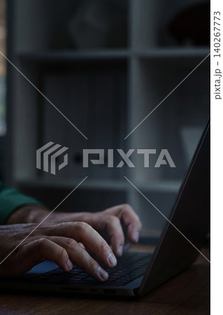 Scam message appears on laptop screen while a person types in a home office 140267773