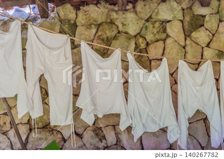 Embroidered garments and handmade textiles hang outdoors, showing local craft, folk clothing, cultural heritage and travel detail concept Embroidered garments and handmade textiles hang outdoors, showing local craft, folk clothing, cultural heritage and travel detail concept 140267782