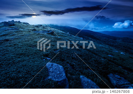 nature scenery with mountain under summer sky at night. full moon over alpine landscape of carpathian mountain with grassy slopes. low fluffy clouds on high altitude. mysterious summer vacations nature scenery with mountain under summer sky at night. full moon over alpine landscape of carpathian mountain with grassy slopes. low fluffy clouds on high altitude. mysterious summer vacations 140267808