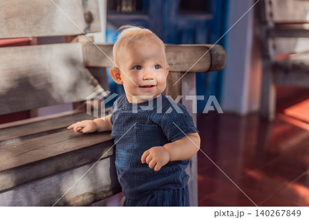 Infant explores polished tile floor and wooden benches in a colonial courtyard, showing baby travel, early steps and family vacation concept Infant explores polished tile floor and wooden benches in a colonial courtyard, showing baby travel, early steps and family vacation concept 140267849