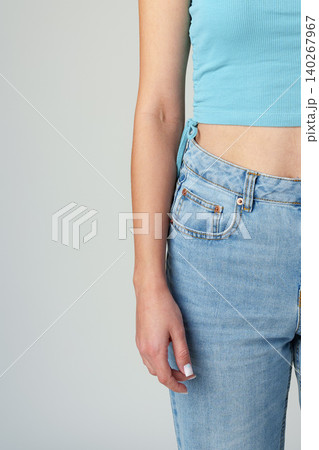 Fashion look with casual outfit featuring blue crop top and denim jeans on a plain background Fashion look with casual outfit featuring blue crop top and denim jeans on a plain background 140267967