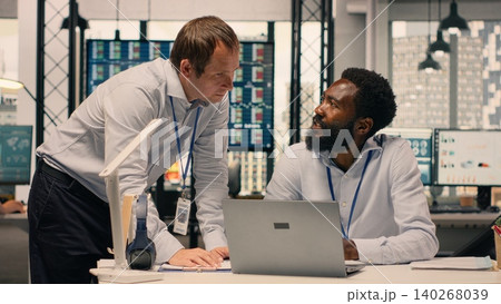Corporate collaboration, diverse professionals, business intelligence, forecasting data, laptop and reports, productivity and decision making. Productivity, organizational data analysis. 140268039