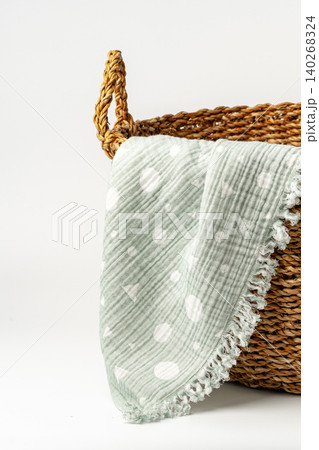 Soft green blanket placed on woven basket for home decor storage in a cozy space Soft green blanket placed on woven basket for home decor storage in a cozy space 140268324