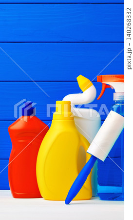 Various cleaning supplies arranged on a table with a blue wooden background 140268332