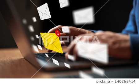 Typing a message in response to received emails while working on a laptop Typing a message in response to received emails while working on a laptop 140268414