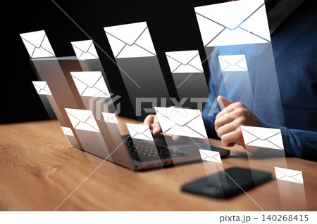 Person typing on a laptop with email notifications displayed on the screen Person typing on a laptop with email notifications displayed on the screen 140268415