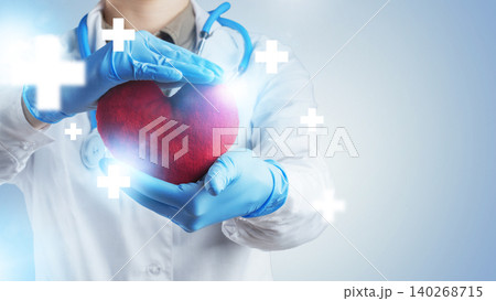 Health professional holds heart symbol in hands at medical facility during work hours Health professional holds heart symbol in hands at medical facility during work hours 140268715