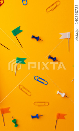 Colorful stationery items scattered on a bright yellow surface during daylight hours 140268722