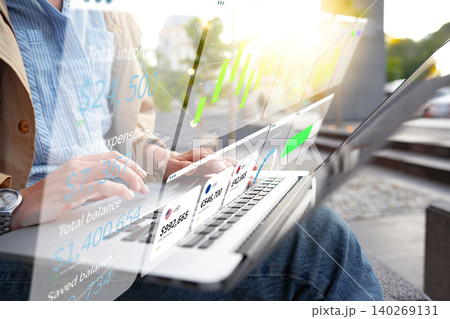 Digital business chart shows financial data on laptop in outdoor setting during sunny day 140269131