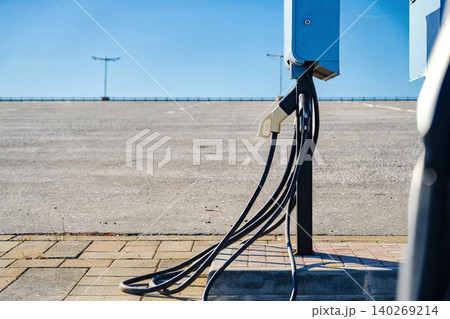 Electric car charger station in empty parking lot on clear day 140269214