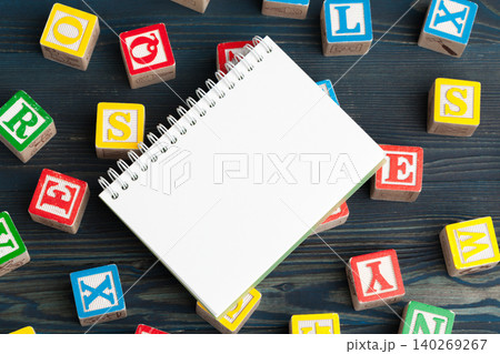 Notepad on wooden table and wood alphabet blocks Notepad on wooden table and wood alphabet blocks 140269267
