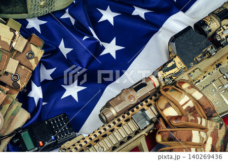 U.S. battle flag and assault rifle on the wooden table. 140269436