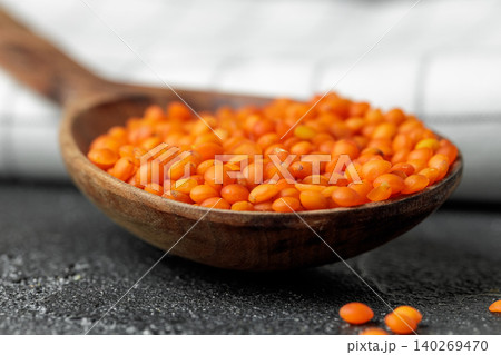 Wooden spoon with red lentils close up Wooden spoon with red lentils close up 140269470