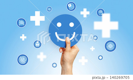 Hand holds blue circle with smiley face and health symbols in blue background 140269705