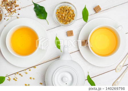 teapot and cups of tea on a white wooden background 140269798