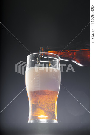 Beer pouring into glass on black background Beer pouring into glass on black background 140269898