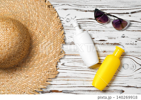 Straw hat, sunglasses and sunscreen bottle on wooden background 140269918