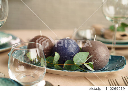 Luxury green table setting decorated with candles Luxury green table setting decorated with candles 140269919