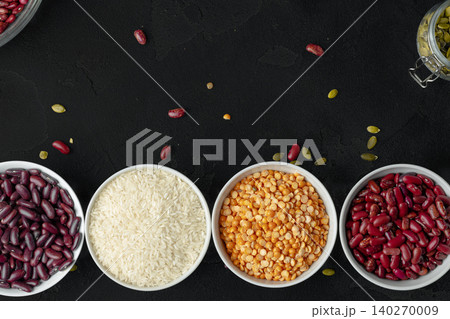 Top view of ceramic bowls with assorted grains on wooden table 140270009