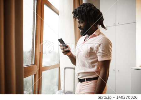 Bearded young african american man looking at his smartphone Bearded young african american man looking at his smartphone 140270026