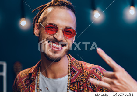 Stylish guy with dreadlocks wearing pink sunglasses 140270182