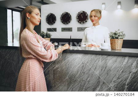 Blonde woman hotel guest checking-in at front desk in hotel Blonde woman hotel guest checking-in at front desk in hotel 140270184