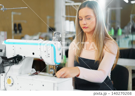 Portrait of seamstress working with sewing machine 140270208