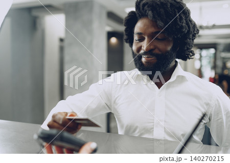 African man businessman paying for the stay in hotel with credit card African man businessman paying for the stay in hotel with credit card 140270215