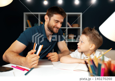 Father helping his little son with school homework Father helping his little son with school homework 140270260