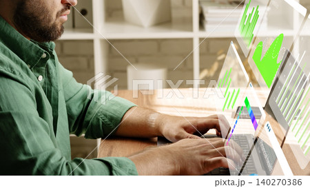 Working with digital business chart tools on a laptop at a desk in a modern office 140270386