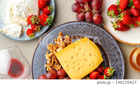 Cheese and fruit platter with wine glass on a tabletop during a gathering 140270427