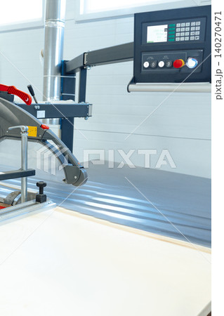 Cutting tool in use on a work table inside a manufacturing facility during daylight hours Cutting tool in use on a work table inside a manufacturing facility during daylight hours 140270471