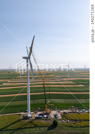 Wind turbine installation using a large construction crane. The assembly process of the turbine tower and rotor blades. Aerial view. 140271169
