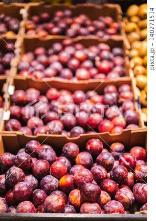 Fresh ripe plums arranged in supermarket fruit display with colorful organic produce and healthy grocery shopping concept Fresh ripe plums arranged in supermarket fruit display with colorful organic produce and healthy grocery shopping concept 140271514