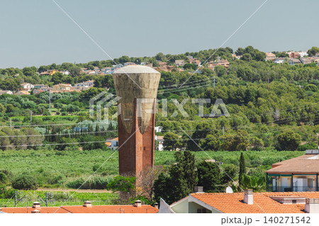 Historic concrete water tower rising above green Mediterranean landscape and residential area near Sant Salvador Historic concrete water tower rising above green Mediterranean landscape and residential area near Sant Salvador 140271542