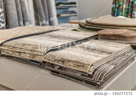 Folded carpet and rug samples displayed on table in home improvement store Folded carpet and rug samples displayed on table in home improvement store 140271572